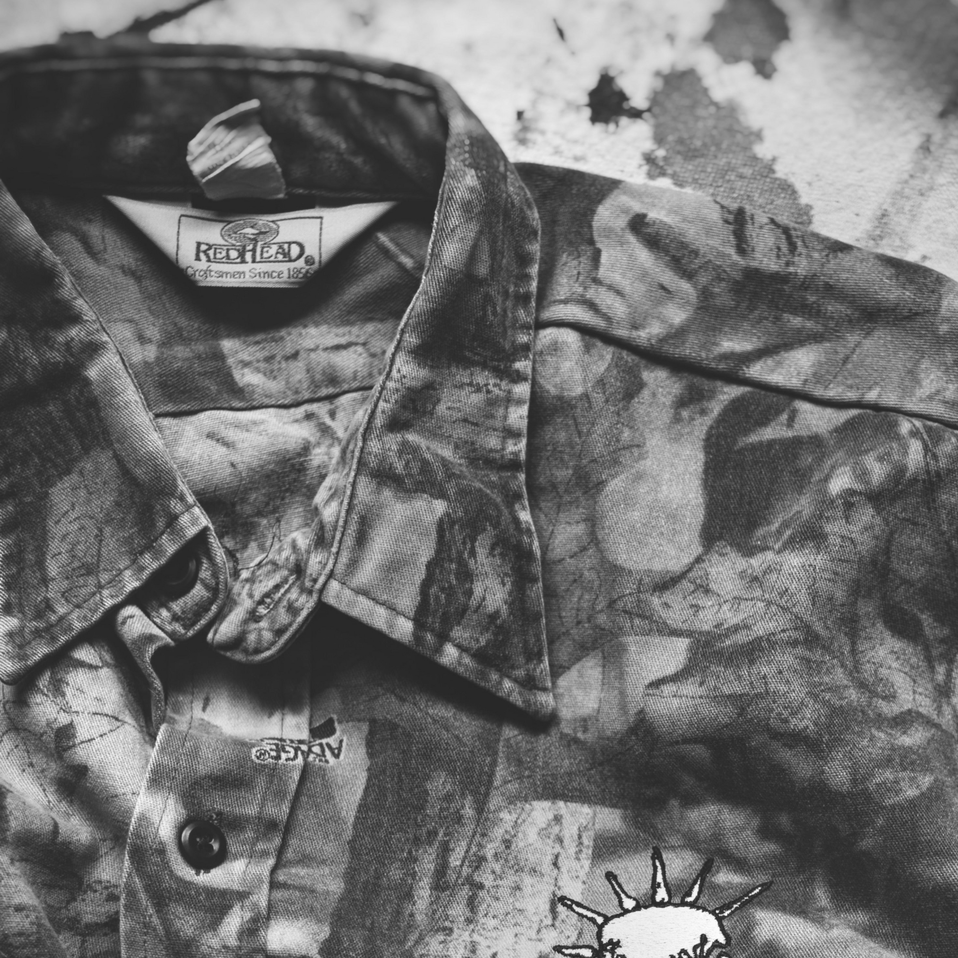 Camouflage jacket with DNO Skull logo on the chest. Closeup feat Redhead tag