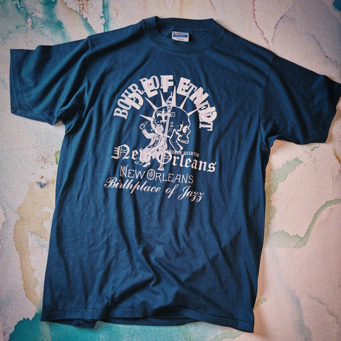 Blue t-shirt with white text and graphics on a textured surface